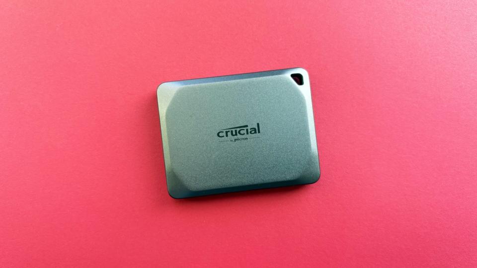 Tragbares Crucial X9 Pro auf rotem Hintergrund.