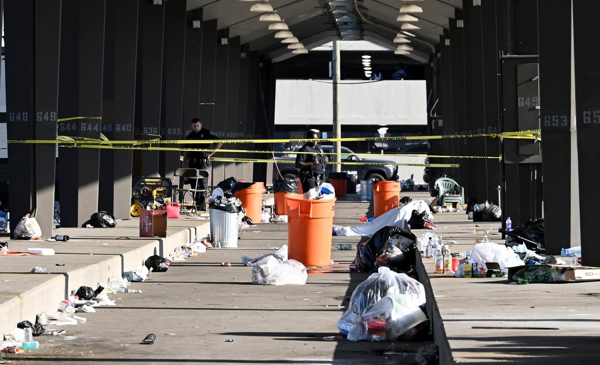 Ein Polizist steht hinter Absperrband, gesehen am Ort einer Schießerei in Hut 6 am Eastern Market in Detroit, Sonntag, 15. September 2024.