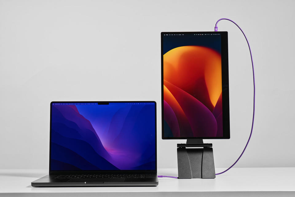 MacBook neben einem tragbaren Monitor, der vertikal auf einem Ständer steht.
